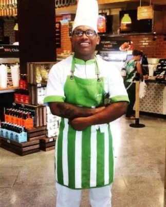 Edd Cabarcas con delantal verde de rayas dentro del supermercado